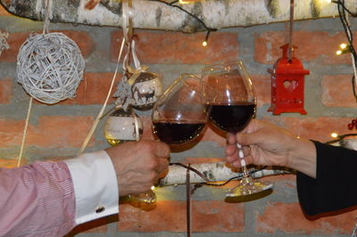 Cropped hands toasting wineglasses