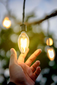 Close-up of hand holding light bulb