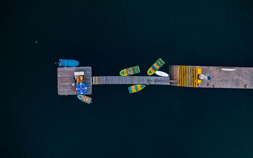 Aerial view of boats moored by pier on sea