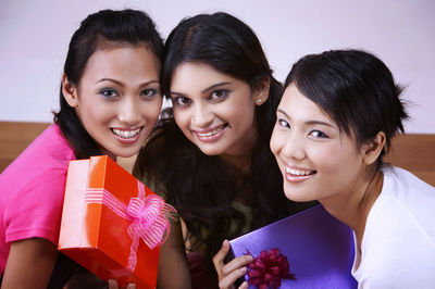 Portrait of smiling young woman holding camera in box