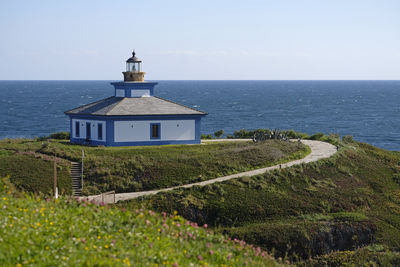 Lighthouse by sea against sky