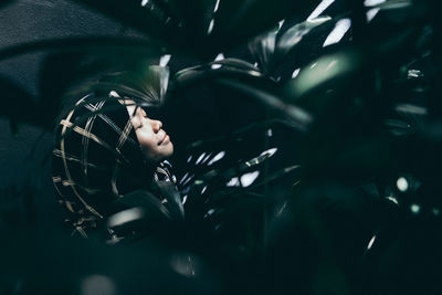 Close-up of woman amidst plants at night