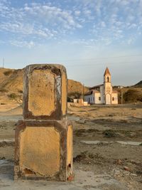 Old ruined building on field against sky