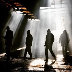 Silhouette people standing in illuminated room