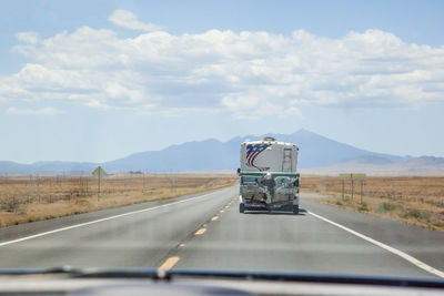 Vehicle on country road seen through car windshield