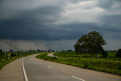 Road amidst trees against sky