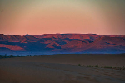 Scenic view of desert against sky during sunset