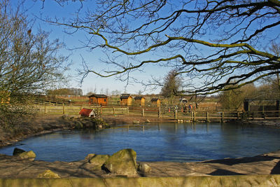 Wet bridge over river against sky