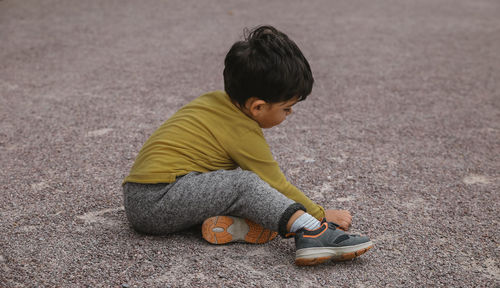 Cute boy sitting on land