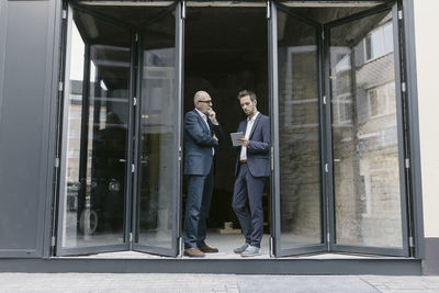 Senior and mid-adult businessman with tablet having a meeting