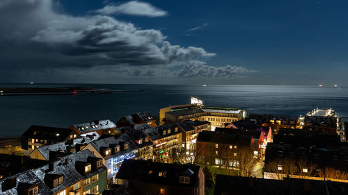 Aerial view of illuminated buildings against sky at dusk