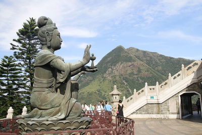 Statue of buddha against cloudy sky