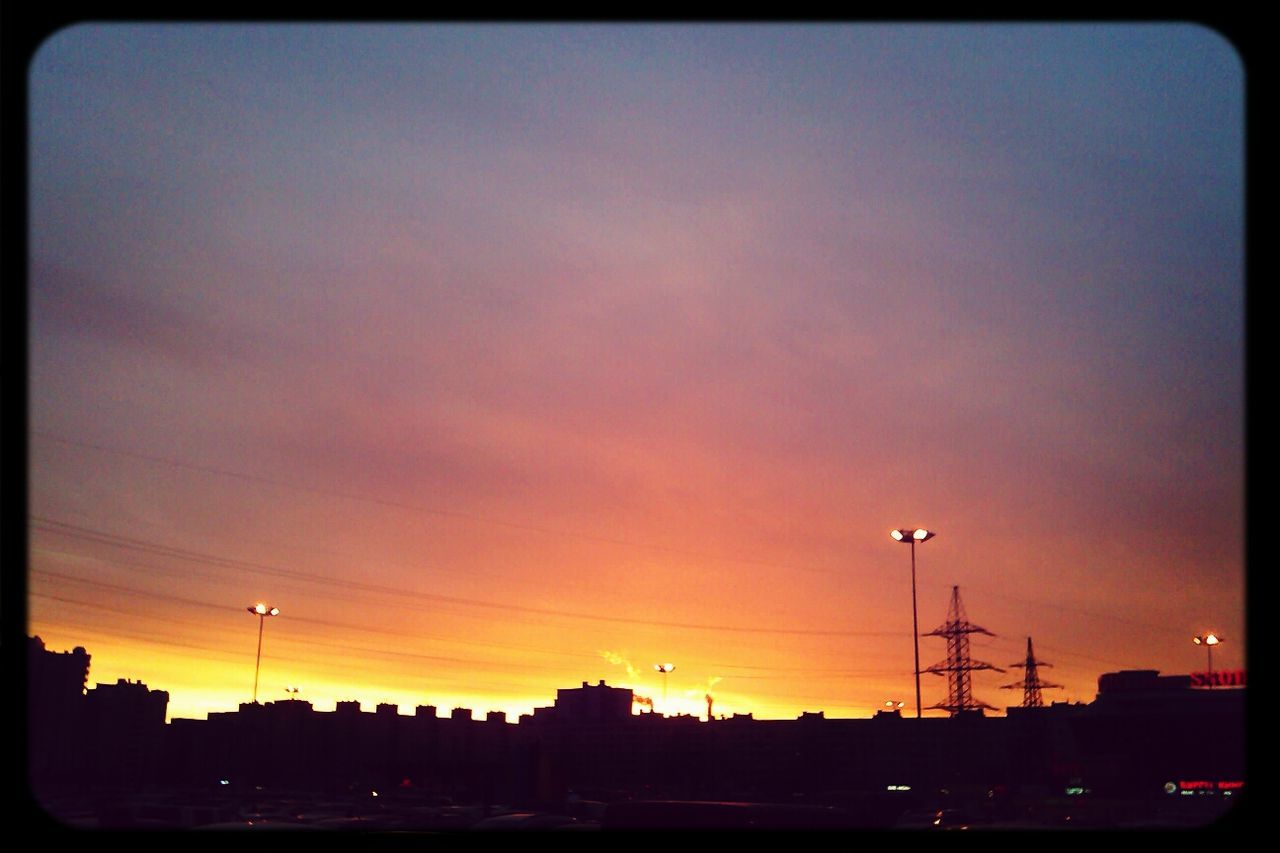 sunset, silhouette, sky, building exterior, street light, built structure, architecture, orange color, city, dusk, cloud - sky, dark, beauty in nature, dramatic sky, scenics, power line, low angle view, nature, cloud, outdoors