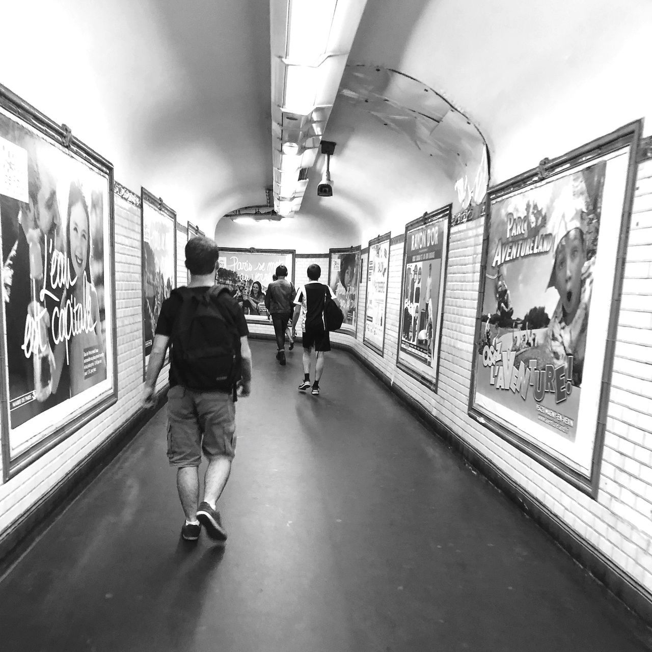 group of people, public transportation, real people, transportation, rail transportation, architecture, lifestyles, walking, men, women, rear view, people, travel, mode of transportation, adult, leisure activity, motion, indoors, subway, medium group of people, subway train, ceiling