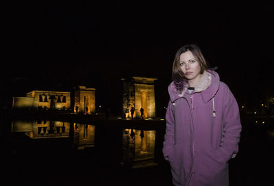 Portrait of woman standing at temple of debod during night