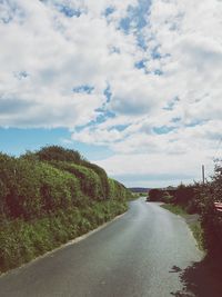 Road amidst trees against sky