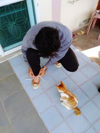 High angle view of child with dog on tiled floor