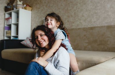 Portrait of smiling girl sitting on sofa