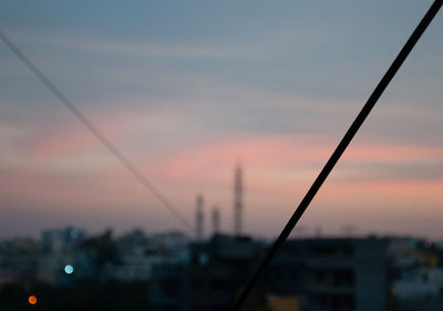 Silhouette buildings against sky at sunset