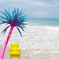 Coconut palm tree on beach against sky