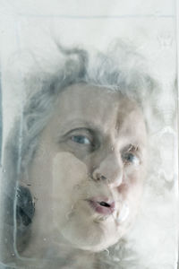 Close-up portrait of young woman against white background