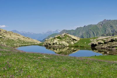 Scenic view of lake and mountains against clear sky