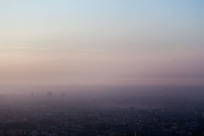 Aerial view of city against sky during sunset