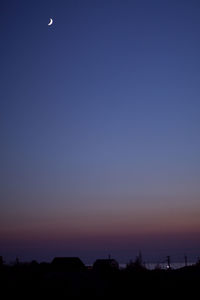 Silhouette trees against clear blue sky during sunset