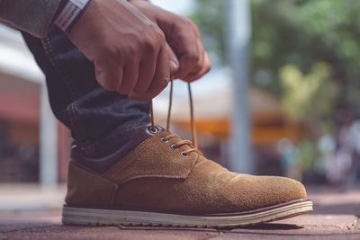 Low section of man wearing shoes