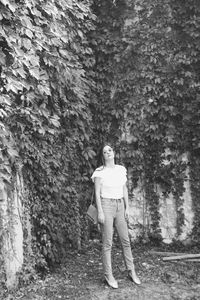 Full length of woman standing against plants