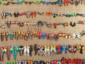 Full frame shot of colorful bird shapes key rings for sale at market