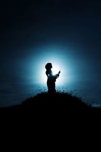 Side view of silhouette man standing on field against sky