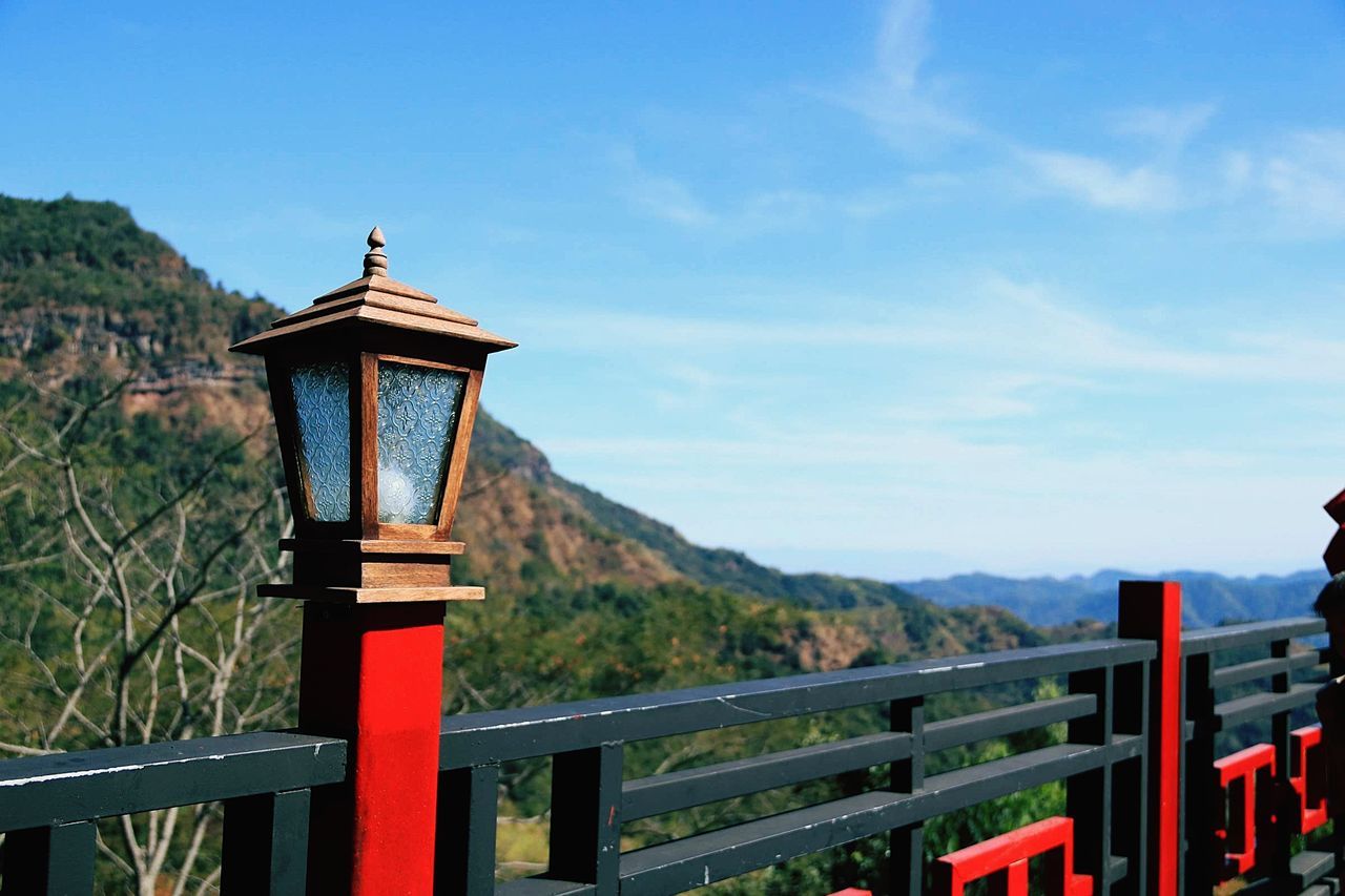 sky, mountain, built structure, architecture, nature, day, no people, scenics - nature, security, religion, belief, railing, lighting equipment, focus on foreground, barrier, spirituality, boundary, tranquility, fence, outdoors