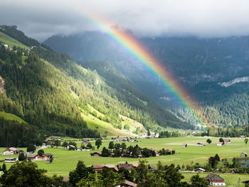 Scenic view of rainbow over mountains against sky