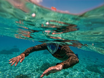 Man in mask swimming in sea 