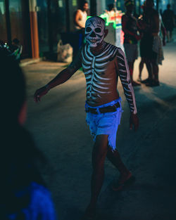 Rear view of man walking on street at night