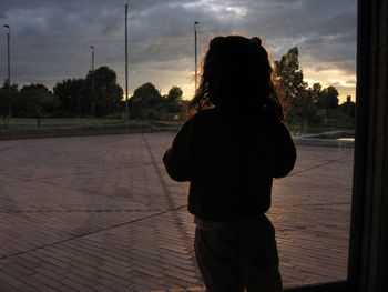 Silhouette of woman against cloudy sky