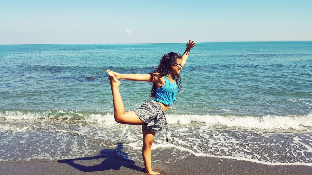 WOMAN STANDING ON BEACH