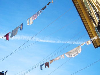 Low angle view of flags against blue sky