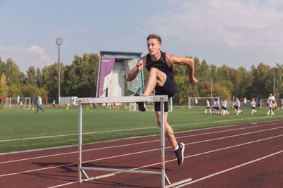 Full length of woman exercising on field