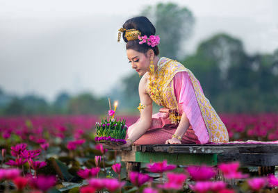 Woman sitting by pink flower