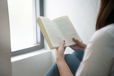 Midsection of woman reading book