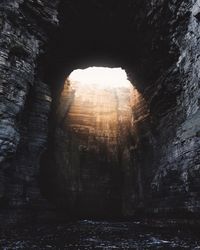 Sunlight streaming in cave by sea