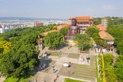 High angle view of statue amidst buildings in city