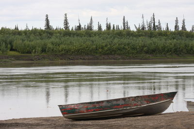 Boat moored on shore against sky