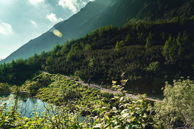 Scenic view of river by mountains against sky