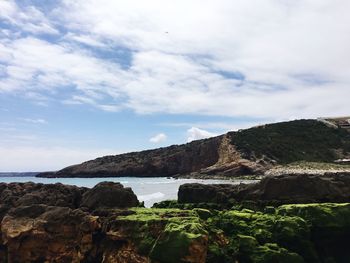 Scenic view of sea and mountains against sky