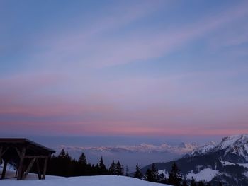 Scenic view of snow covered landscape against sky during sunset