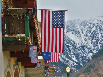 American flag hanging against snowcapped mountains