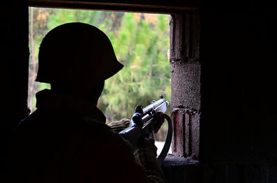 Rear view of soldier holding rifle